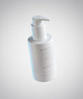 White bottle with pump dispenser on a light gray background